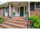 Inviting front entry with brick steps, decorative planters, and charming green door with wreath at 2515 Sheffield Dr, Gastonia, NC 28054