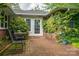 Charming brick patio with seating area, surrounded by lush greenery and featuring a door with decorative window accents at 2515 Sheffield Dr, Gastonia, NC 28054