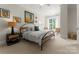 Well-lit bedroom features a modern bed, nightstand, and comfortable seating area with a view at 2823 Providence Rd # 143, Charlotte, NC 28211