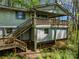 Charming cottage-style home featuring a wooden deck and two sets of exterior wooden staircases, set amongst mature trees at 322 Electra Ln, Stanley, NC 28164
