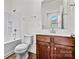 Bright bathroom with a shower-tub combo and a modern vanity with wood cabinets and a white countertop at 322 Flat Rock Dr, Denver, NC 28037