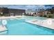Large community pool featuring a modern clubhouse, landscaped grounds, and many lounge chairs at 322 Flat Rock Dr, Denver, NC 28037
