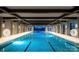 A well lit indoor pool with dark wooden beams and a decorative brick wall at 322 Flat Rock Dr, Denver, NC 28037