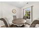 Cozy dining nook with round table, four tufted chairs, and natural light from window at 3224 Selwyn Farms Ln # 3, Charlotte, NC 28209