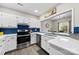 Bright kitchen featuring white cabinets, stainless steel appliances, and open view into the dining area at 3224 Selwyn Farms Ln # 3, Charlotte, NC 28209