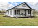 Charming home featuring a covered porch with chairs, black shutters, and a well-maintained front yard at 382 Cole Campbell Rd, Taylorsville, NC 28681