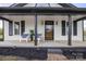 Charming home featuring a covered front porch with chairs and beautiful landscaping at 382 Cole Campbell Rd, Taylorsville, NC 28681