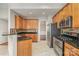 Well-equipped kitchen with granite countertops, stainless steel appliances, and natural wood cabinetry at 408 Harvest Ter, Clover, SC 29710