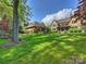 Spacious backyard features Tudor home, outdoor kitchen, pool, and lush lawn; great for outdoor entertainment and relaxation at 4400 Sharon View Rd, Charlotte, NC 28226