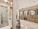 Elegant bathroom boasting a glass shower and vanity with marble countertops, lit by a chandelier at 4400 Sharon View Rd, Charlotte, NC 28226