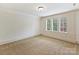 Bright, carpeted bedroom with decorative trim, featuring three windows offering natural light and views at 4400 Sharon View Rd, Charlotte, NC 28226
