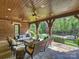 Covered outdoor porch with wood ceiling and stone flooring offers a beautiful view of the landscaped backyard at 4400 Sharon View Rd, Charlotte, NC 28226