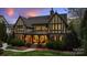 Elegant home exterior at dusk, featuring well-lit porch and beautifully landscaped front yard at 4400 Sharon View Rd, Charlotte, NC 28226