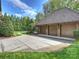 Spacious three-car garage with ample parking and driveway space surrounded by lush landscaping at 4400 Sharon View Rd, Charlotte, NC 28226