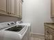 Functional laundry room featuring modern washer and dryer, complemented by built-in storage cabinets at 4400 Sharon View Rd, Charlotte, NC 28226