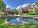 Backyard pool area features pristine pool and hot tub adjacent to the outdoor kitchen on a lush manicured lawn at 4400 Sharon View Rd, Charlotte, NC 28226