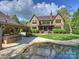Backyard pool area with outdoor kitchen, manicured lawn, and beautiful Tudor home offers a luxurious outdoor living space at 4400 Sharon View Rd, Charlotte, NC 28226