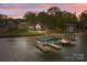Stunning waterfront home featuring a private boat dock and lush landscaping at sunset at 477 Big Indian Loop, Mooresville, NC 28117