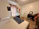 Casual bedroom featuring neutral tones, carpet, and a comfortable bed with patterned bedding at 4927 Curtiswood Dr, Charlotte, NC 28213