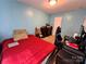 Cozy bedroom features light blue walls, red bedding, and a functional desk setup, blending relaxation with productivity at 4927 Curtiswood Dr, Charlotte, NC 28213