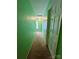 Narrow hallway with green walls, beige carpet, and a window at the end providing natural light at 4927 Curtiswood Dr, Charlotte, NC 28213