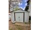 Metal shed in a backyard with brown trim, providing storage with a solid foundation at 4927 Curtiswood Dr, Charlotte, NC 28213