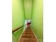 Carpeted steps lead downstairs with wood railing and vibrant walls at 4927 Curtiswood Dr, Charlotte, NC 28213