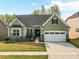 Charming green home with stone accents, manicured lawn, and a two-car garage with an inviting curb appeal at 4989 Samoa Ridge Dr, Lancaster, SC 29720