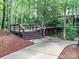 Wooden deck with metal railing on a wooded lot with a concrete path at 4989 Samoa Ridge Dr, Lancaster, SC 29720