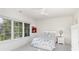 Bright bedroom with large window, ceiling fan, and a cozy bed with colorful bedding and a bedside table at 510 Poindexter Dr, Charlotte, NC 28209