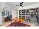 Well-lit office with hardwood floors, desk space, large bookcase, and a comfortable rug for a productive workspace at 510 Poindexter Dr, Charlotte, NC 28209