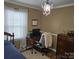 Bedroom with neutral walls, wood accents, desk, and a decorative chandelier at 526 Arlington Ave, Albemarle, NC 28001