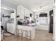 Eat-in kitchen boasts breakfast bar, white cabinetry, stainless appliances, and easy access to the laundry at 5762 Hightower Rd, Fort Lawn, SC 29714