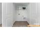 Compact laundry room ready for your washer and dryer, featuring overhead shelving and tile flooring at 6215 Honor Ave, Midland, NC 28107