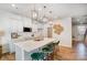 Modern kitchen features white cabinets, stainless appliances, quartz countertops, an island with seating, and wood floors at 6427 Mallow Crossing Ln, Charlotte, NC 28213