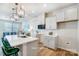 Modern kitchen features white cabinets, stainless appliances, quartz countertops, an island with seating, and wood floors at 6427 Mallow Crossing Ln, Charlotte, NC 28213