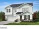 Charming two-story home boasts stone accents, dark shutters, white siding, a well-manicured lawn, and attached garage at 6882 Wilson Creek Dr, Indian Land, SC 29707