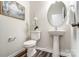 Chic powder room with pedestal sink, oval mirror, and minimalist decor at 7144 Hodges Meadow Ln, Charlotte, NC 28213