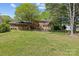 Charming brick home with a well-manicured lawn, a patio set, and lovely sunroom addition in the backyard at 9607 Stoney Hill Ln, Charlotte, NC 28277