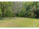 Expansive backyard featuring mature trees and a storage shed, perfect for outdoor activities at 9607 Stoney Hill Ln, Charlotte, NC 28277