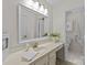 Bright bathroom featuring a large mirror, vanity with sink, and a separate toilet area at 9607 Stoney Hill Ln, Charlotte, NC 28277