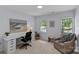 Bright bedroom features a comfortable chair, desk, and view from its light-filled windows at 9607 Stoney Hill Ln, Charlotte, NC 28277