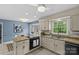 Open kitchen with granite countertops, island cooktop, and blue accent wall at 9607 Stoney Hill Ln, Charlotte, NC 28277