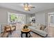 Bright living room showcasing a comfortable couch and a view into the sunroom with natural light at 9607 Stoney Hill Ln, Charlotte, NC 28277