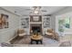 Inviting living room featuring a brick fireplace with built-in shelving and two comfortable armchairs at 9607 Stoney Hill Ln, Charlotte, NC 28277