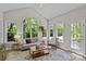 Bright sunroom offering expansive views of the lush greenery and access to the outdoors at 9607 Stoney Hill Ln, Charlotte, NC 28277