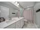 Bright bathroom with a double vanity and shower/tub combination with decorative curtain at 1018 Hinson Forest Rd, Monroe, NC 28110