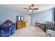 Cozy bedroom with blue walls, ceiling fan, and a view of the neighborhood through a window at 1018 Hinson Forest Rd, Monroe, NC 28110
