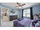 Well-lit bedroom with blue walls, a ceiling fan, a window, and stylish decor at 1018 Hinson Forest Rd, Monroe, NC 28110