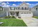 Charming two-story home boasts a well-manicured lawn, covered porch, and a two-car garage at 1018 Hinson Forest Rd, Monroe, NC 28110